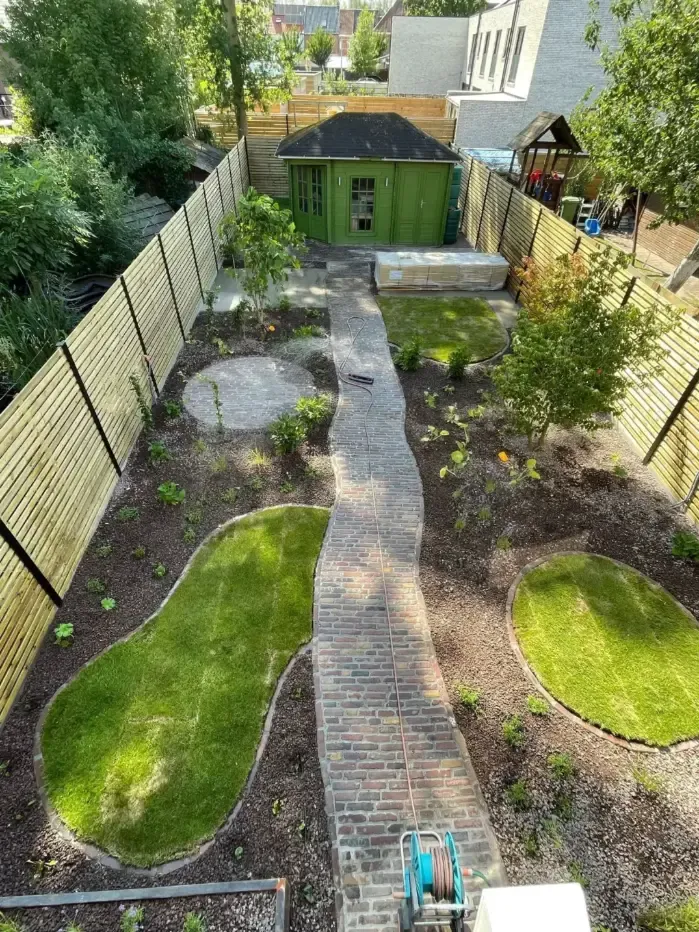 Vakkundige tuinaanleg met terras en beplanting gerealiseerd door Js Tuinen in regio Ninove